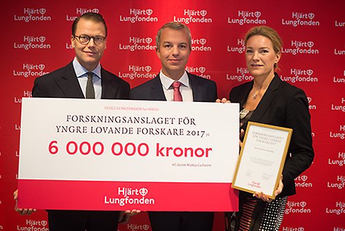 Prins Daniel och Hjärt- och Lungfondens generalsekreterare Kristina Sparreljung överlämnar checken på sex miljoner kronor till docent Mattias Carlström. 