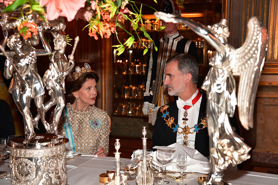Drottningen samtalar med Konungen av Spanien under galamiddagen i Vita Havet. 