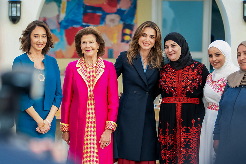 Drottningarna tillsammans med personal på Queen Rania Center.