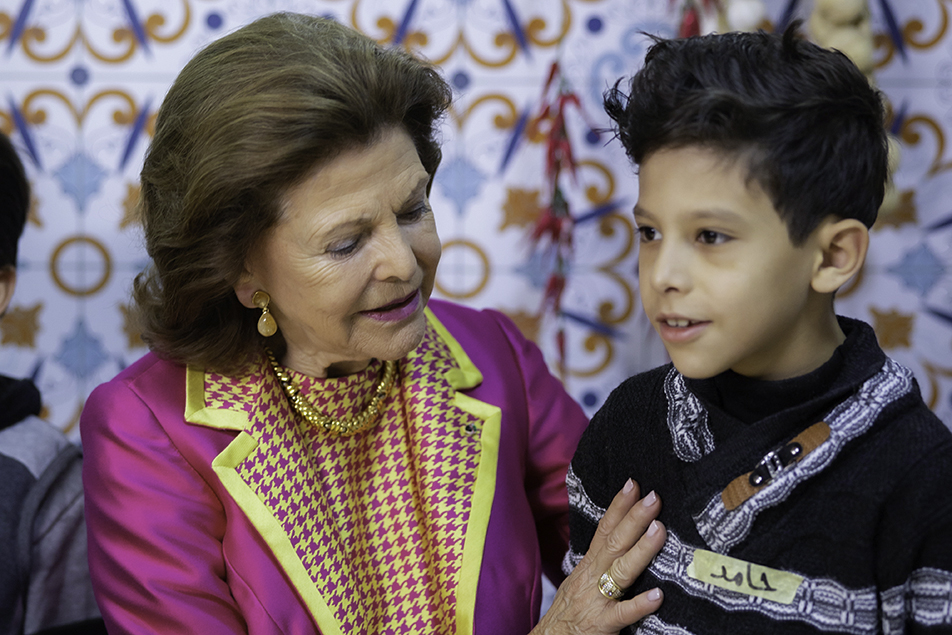 Drottningen tillsammans med en pojke under besöket på Queen Rania Center.