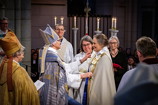 Karin Johannesson kläs på biskopskåpan av ärkebiskopen Antje Jackelén. 