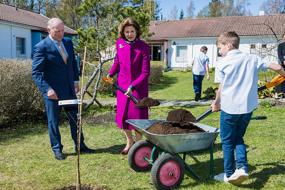 Drottningen planterar ett träd tillsammans med Marcus, 13 år, i SOS Barnby i Keila.