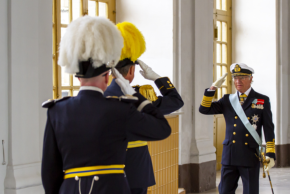 Kungen anländer till dagens ceremoni och hälsar på vaktchefen och slottsväbeln i Kungl. Slottets östra valv.