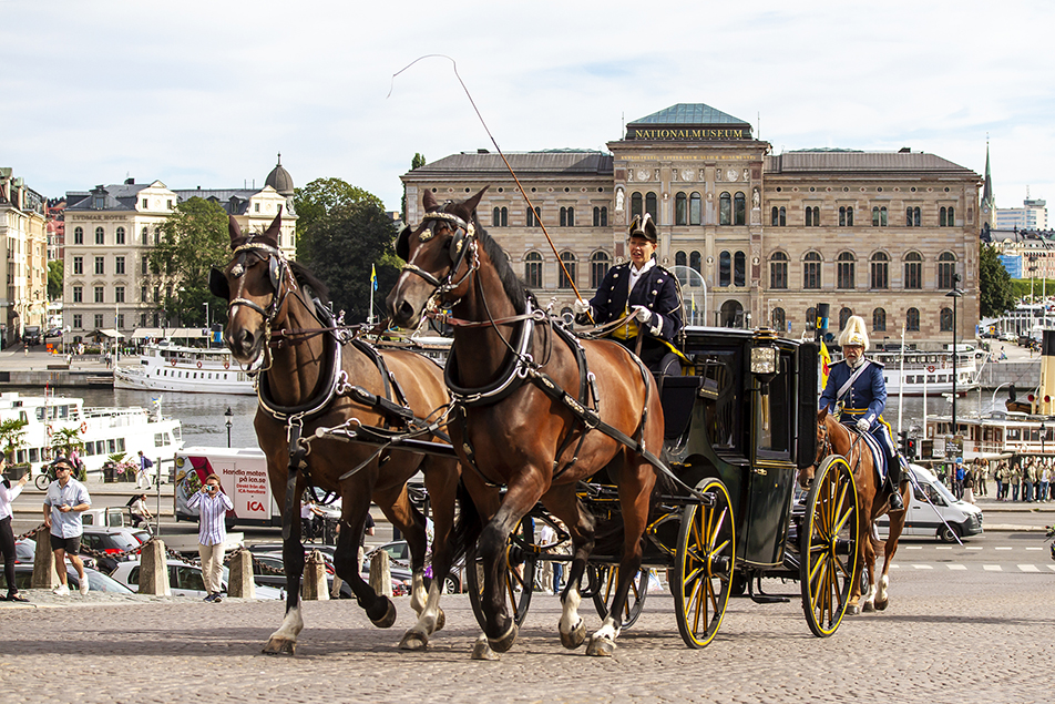 De nyutnämnda ambassadörerna färdas i Hovstallets vagnar uppför Slottsbacken mot Kungl. Slottet. 