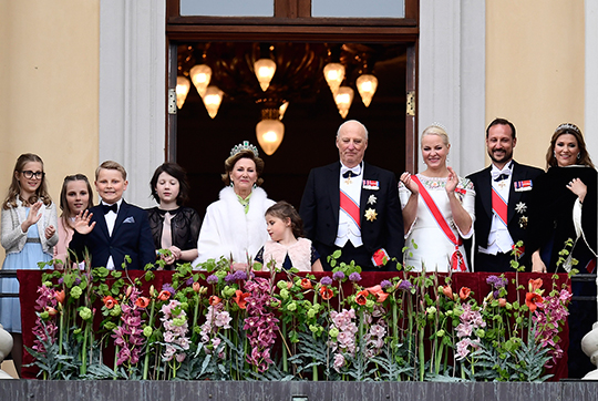 Den norska Kungafamiljen hälsar från slottsbalkongen. 