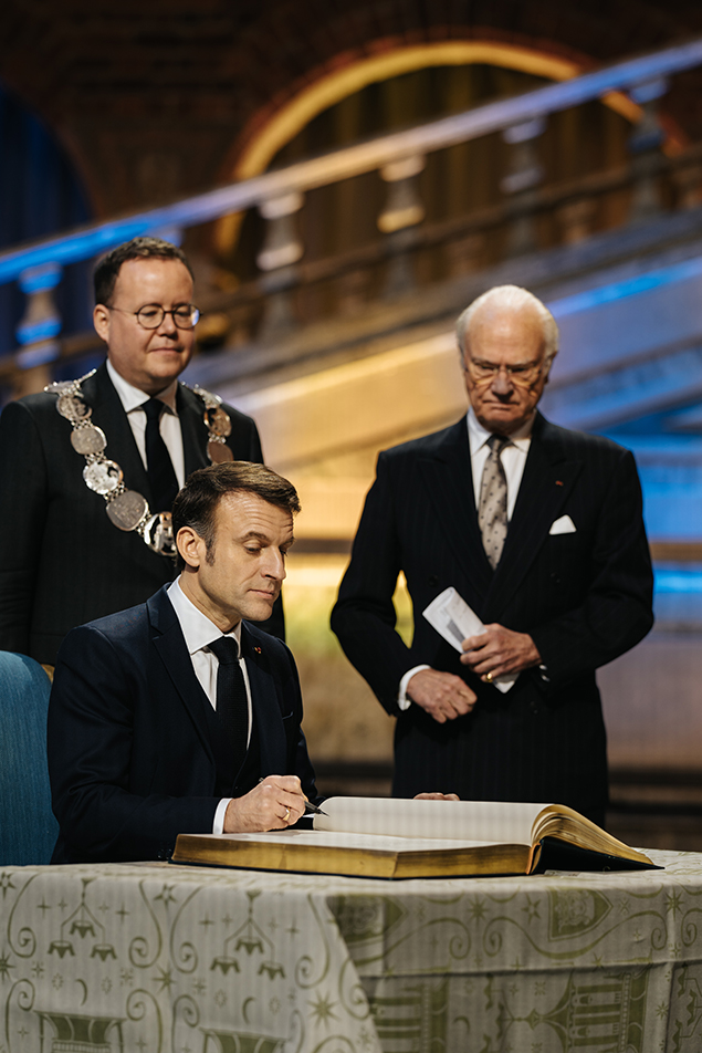 President Macron signs Stockholm City Hall's guest book. 