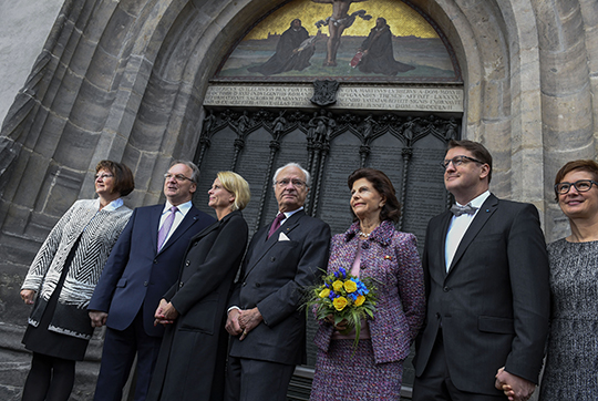 Kungaparet och statsrådet Åsa Regnér tillsammans med Sachsen-Anhalts regeringschef Reiner Haseloff med fru och Wittenbergs borgmästare Torsten Zugehör med fru utanför Slottskyrkan i Wittenberg.