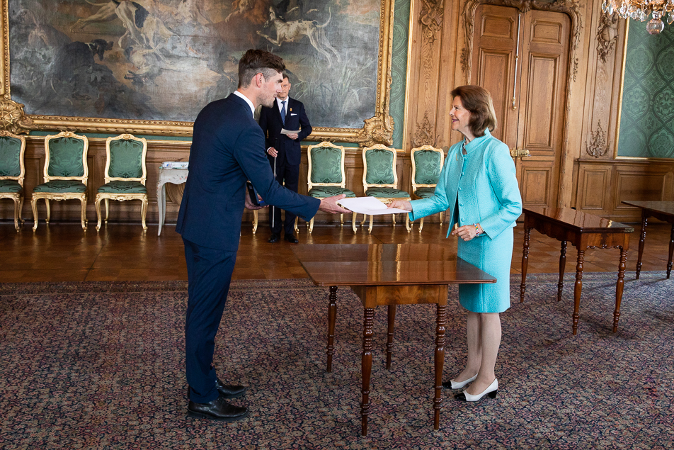 Drottningen överlämnar diplom till skidskytten Fredrik Lindström vid medaljutdelningen på Kungliga slottet. 