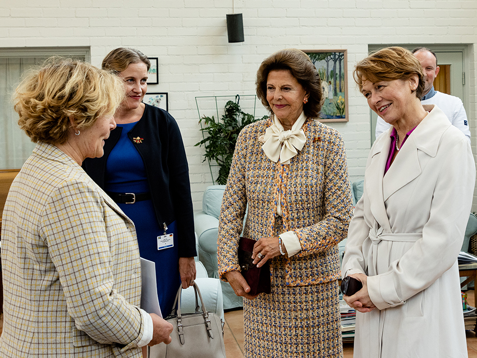 Drottningen och fru Büdenbender samtalar med Silviahemmets rektor och verksamhetschef Wilhelmina Hoffman.