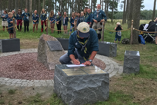 Kungen skriver sitt namn på det minnesmonument som nu finns på Rinkabyfältet. 