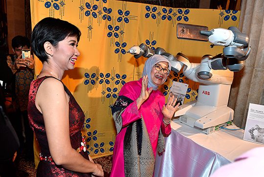 Under Kungaparets mottagning visades utställningar som belyste Sverige ur olika aspekter, med fokus på hållbarhet, innovation och kreativitet. Astrid Damayanti från ABB hjälper Mufidah Kalla att ta en selfie med en robot. 
