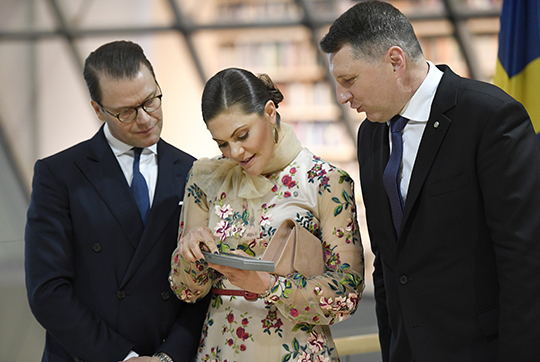 Kronprinsessparet tillsammans med president Raimonds Vējonis under besöket på nationalbiblioteket i Riga. 