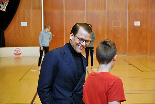 Prins Daniel i samtal med en elev i gymnastiksalen i Juvanpuisto skola i Esbo.