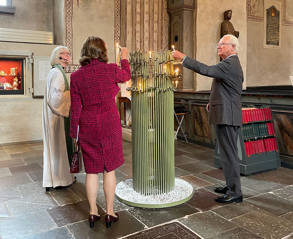 The King and Queen light candles at Old Uppsala Church together with the priest, Dean Annica Anderbrant. 