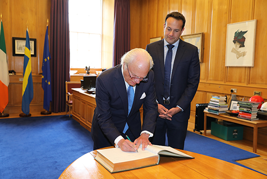 Kungen skriver i premiärministern gästbok. 