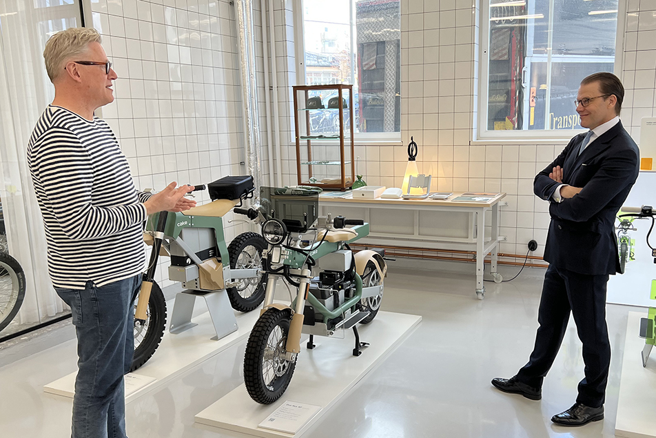 Prins Daniel får en visning av Cakes elmotorcyklar av företagets vd och grundare Stefan Ytterborn.