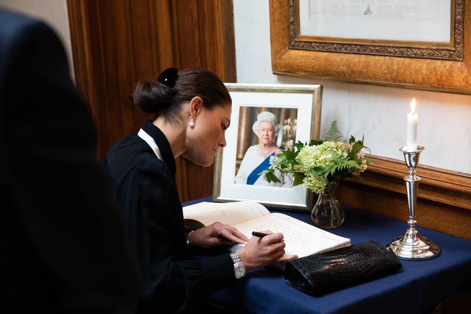Kronprinsessan skriver i ambassadens kondoleansbok. 