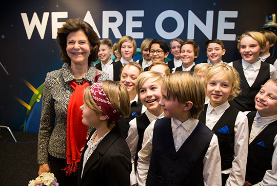 Drottningen tillsammans med barn från Adolf Fredriks musikklasser som framförde ”We Are One”.