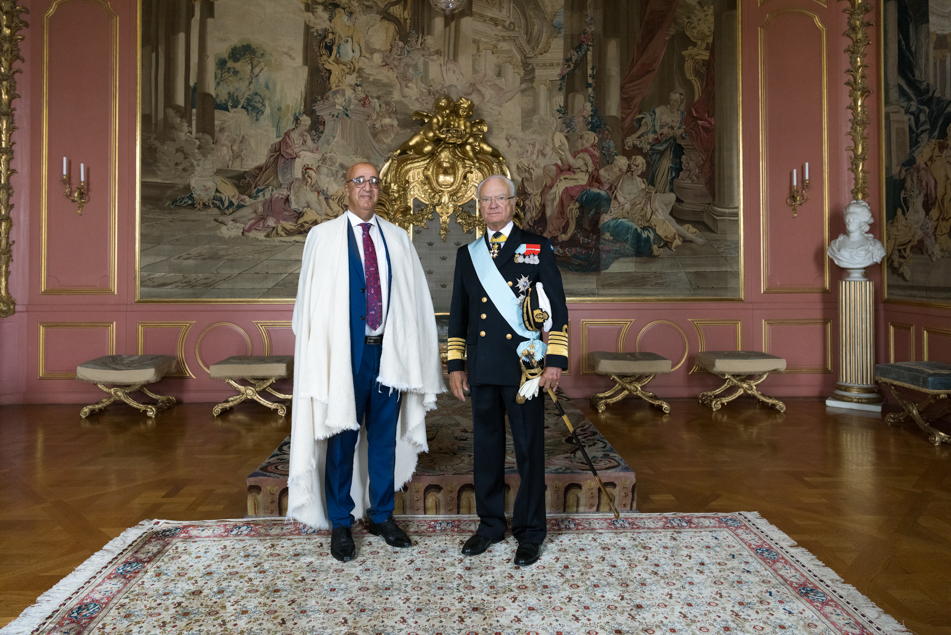 The King greets Algeria's ambassador Seddik Saoudi. 