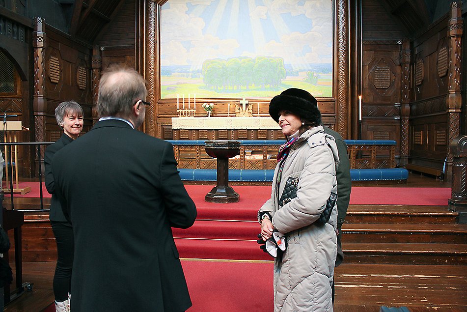Kyrkoherde Heli Pruikkonen och kanslichef Roland Rova guidar Kungaparet genom kyrkan. Altartavlan är målad av prins Eugen. 