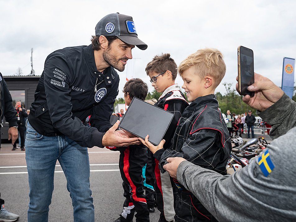 Prince Carl Philip presents the award for participating in the Cadetti RT training race for children at a karting competition at GTR Motor Park in Eskilstuna. 