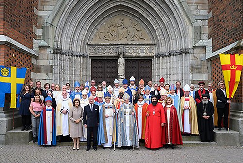 Kungaparet tillsammans med ärkebiskopen, Stockholms nyvigde biskop, Svenska kyrkans övriga biskopar samt utländska gäster utanför Uppsala domkyrka.